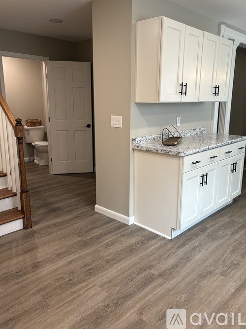A kitchen with white cabinets and a granite countertop.