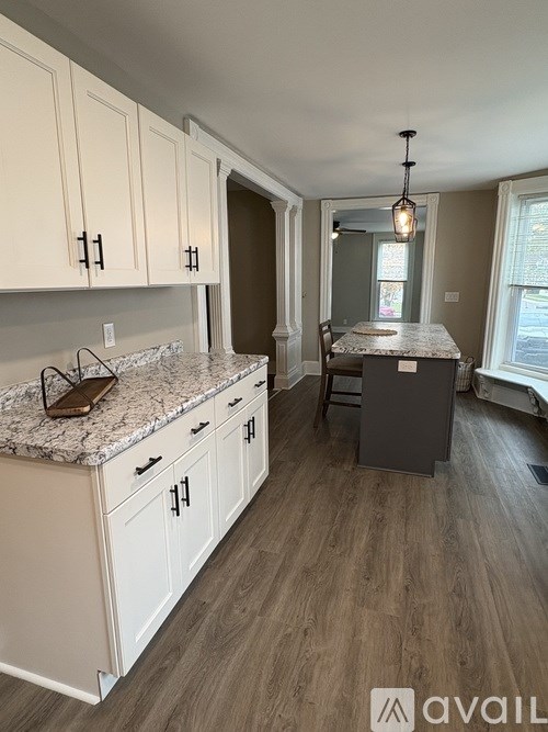 A kitchen with white cabinets and a granite countertop.