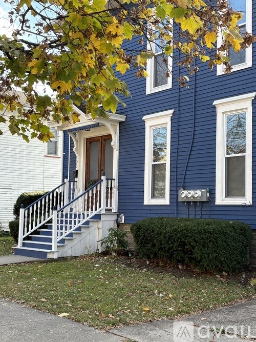A blue house with a white door and windows.