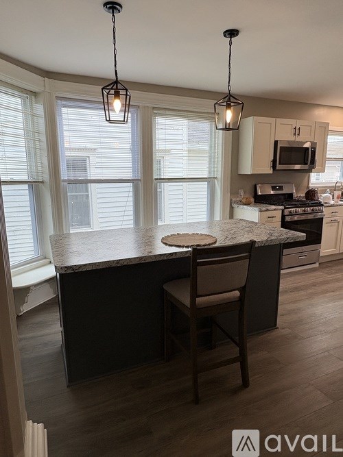 A kitchen with a large island and a chair.