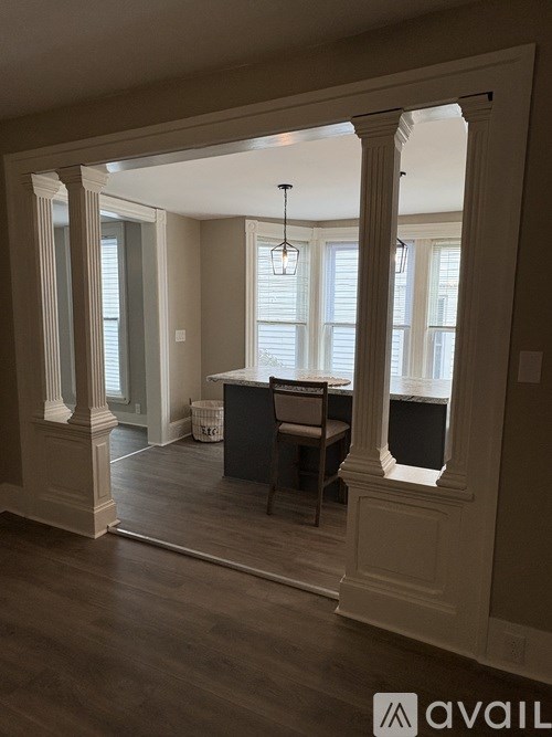 A room with a piano and a window with blinds.