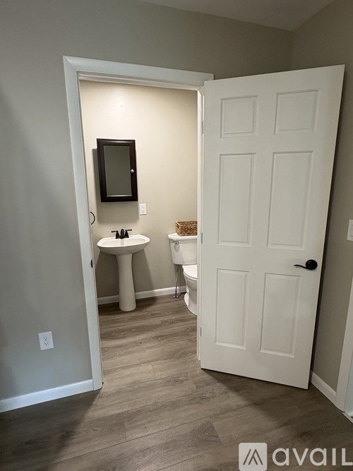 A bathroom with a white door and a white sink.