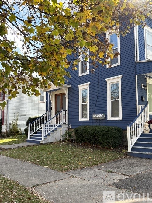 A blue house with a white door and windows.