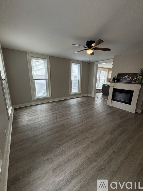 A room with a fireplace and a ceiling fan.