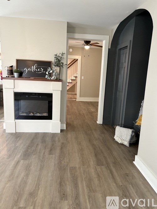 A living room with a fireplace and a sign that says "gather".