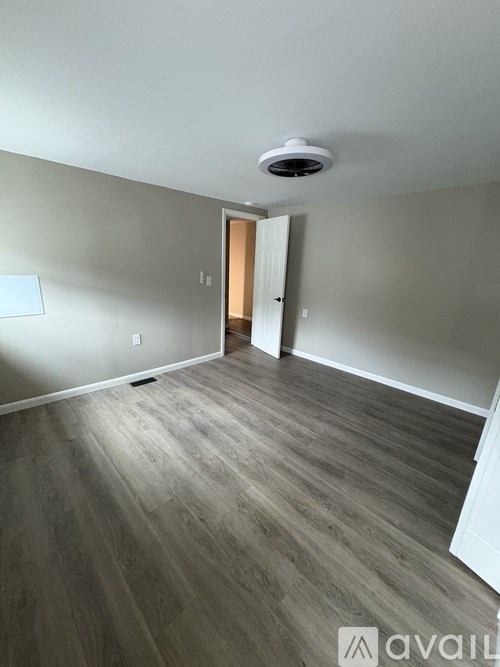 A room with a light on the ceiling and a door on the right.