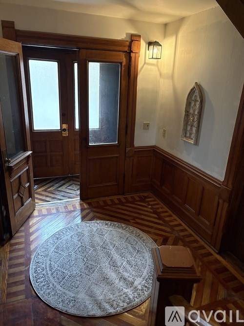A room with a rug on the floor and a wooden door.