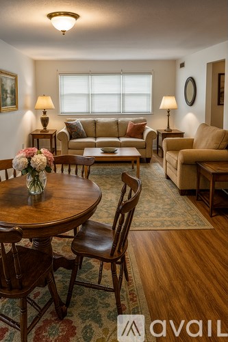 A living room with a table, chairs, and a couch.