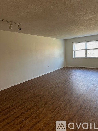 A room with wooden flooring and a window.