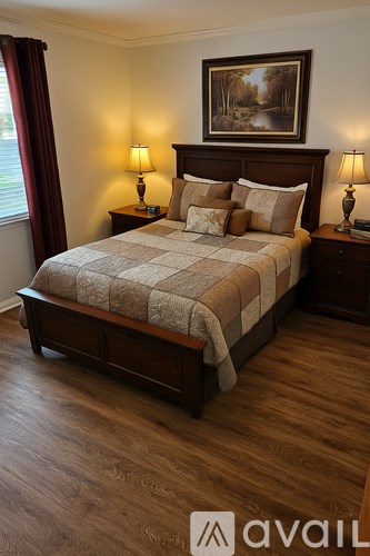 A bedroom with a large bed and a painting on the wall.