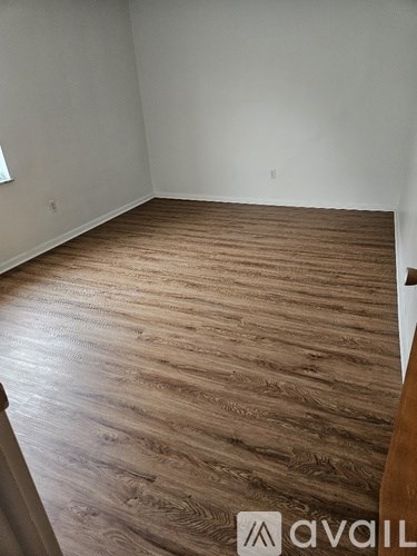 A room with wooden flooring and a white wall.