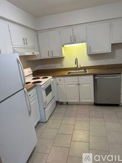 A kitchen with white appliances and cabinets.