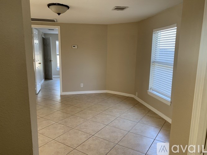 A room with beige walls and a tiled floor.