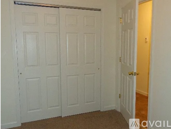 A room with two white doors and a carpeted floor.