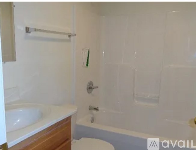 A white bathroom with a towel rack and a toothbrush.