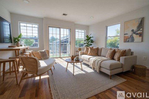 A living room with a couch, chairs, and a rug.