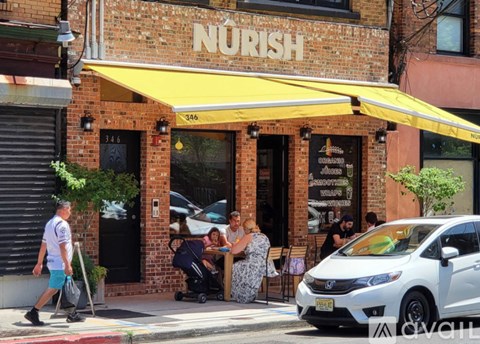 A white car is parked in front of a restaurant.