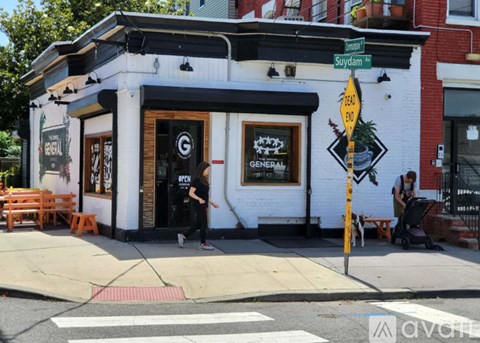 A white building with a black awning and a sign that says "General" on it.