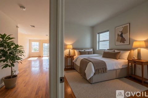 A bedroom with a large bed and a potted plant.