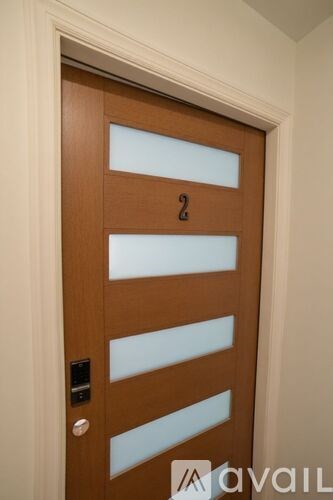 A wooden door with a glass panel and a number 2 on it.