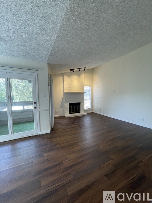 A room with a fireplace and wood flooring.