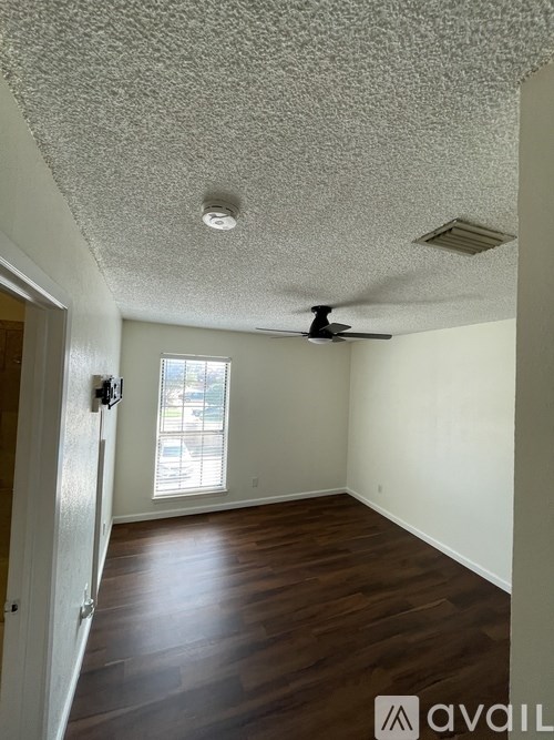 A room with a ceiling fan and a window.