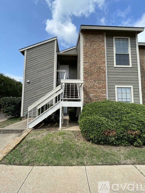 A two-story house with a grey front and a brick exterior.