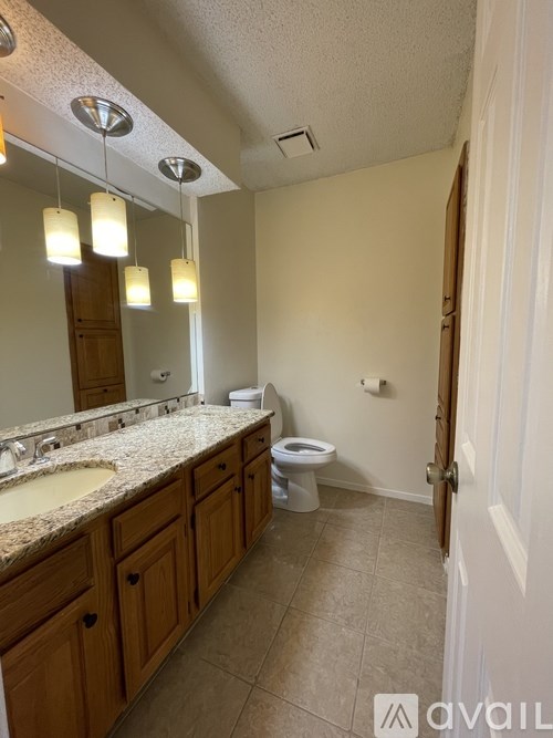 A bathroom with a sink, mirror, and toilet.