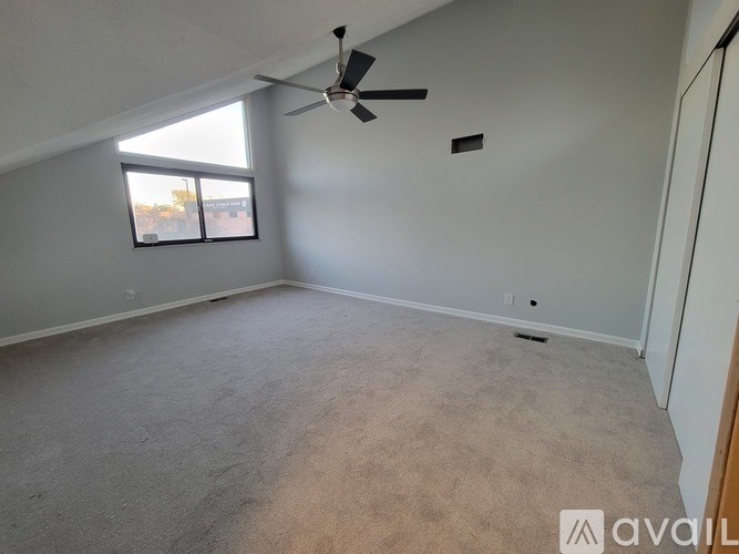 A room with a ceiling fan and a window.