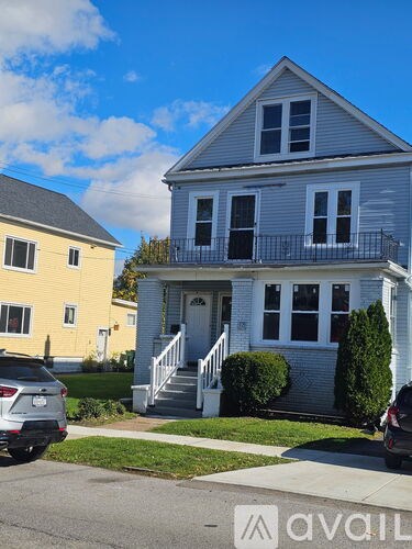 A two-story house with a grey exterior and a white front porch.