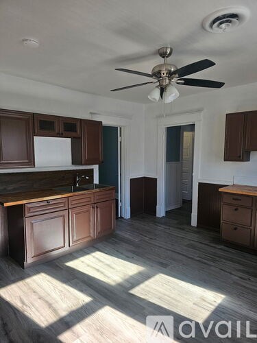 A kitchen with wooden cabinets and a ceiling fan.