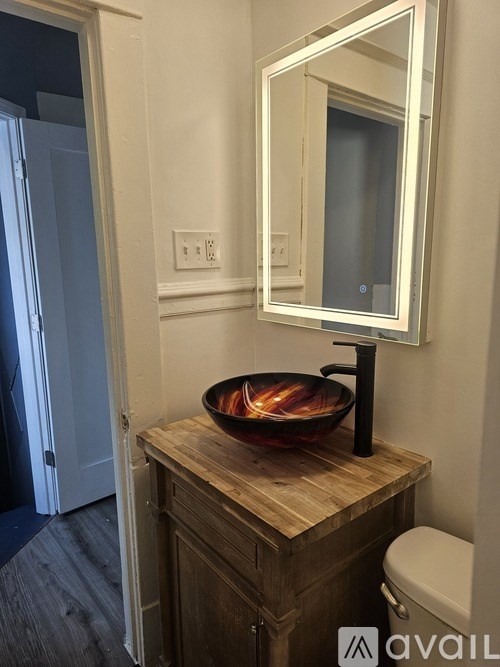 A bathroom with a wooden vanity and a large mirror.