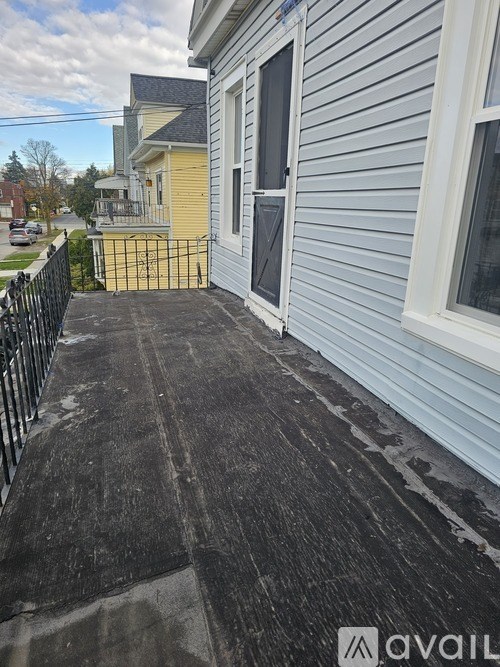 A house with a grey siding and a black railing.