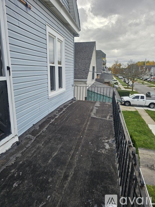 A house with a blue siding and a white truck in the background.
