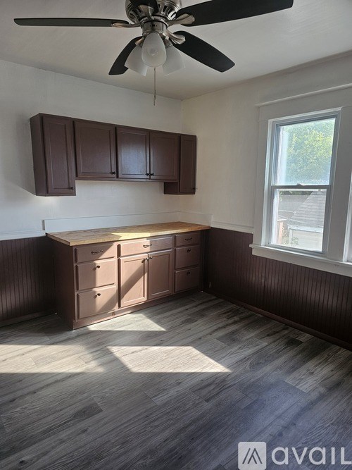 A room with brown cabinets and a ceiling fan.
