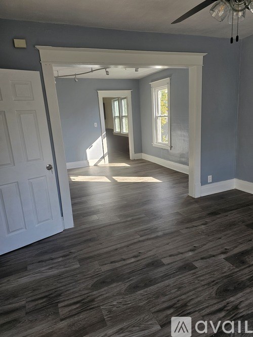 A room with a white door and a window with sunlight coming through.