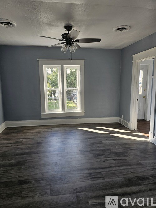 A room with a ceiling fan and a window.
