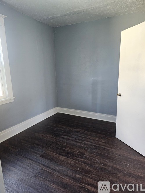 A room with a wooden floor and a white door.