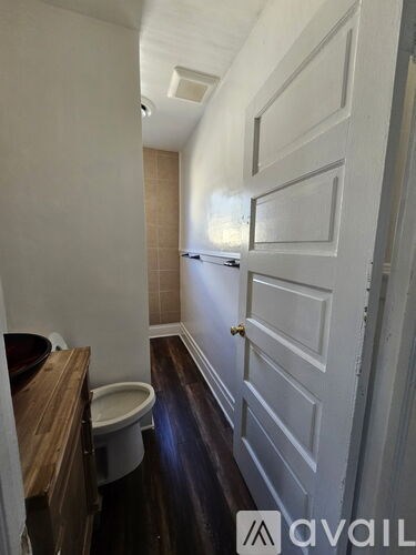 A bathroom with a toilet and a wooden vanity.