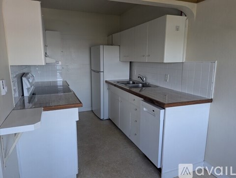 A kitchen with white cabinets and a wooden countertop.