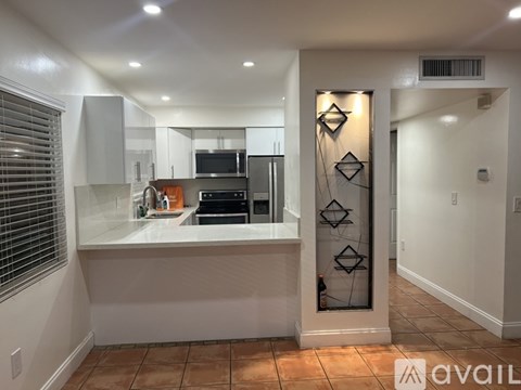 A modern kitchen with a glass door cabinet and a tiled floor.