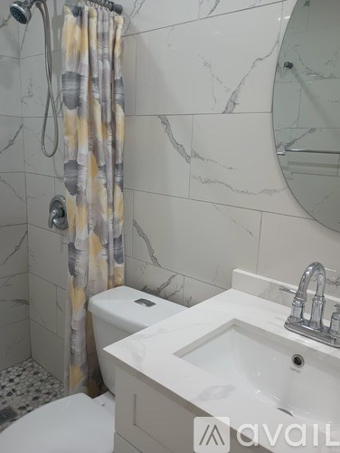 A bathroom with a white toilet, a sink, and a shower curtain.