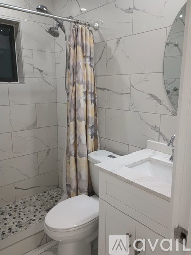 A bathroom with a toilet, sink, and shower.