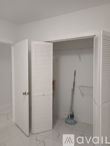 A room with a white door and a vacuum cleaner inside.