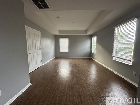 A room with wooden flooring and white walls.