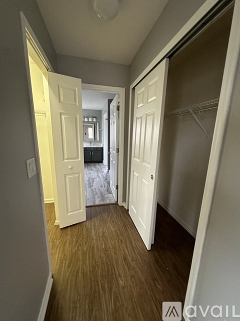 A hallway with two open doors leading to another room.