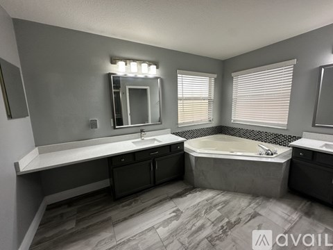 A bathroom with a tub, sink, and mirror.