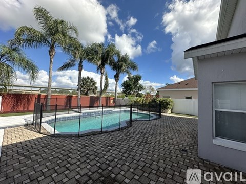 A backyard with a pool surrounded by a black fence.