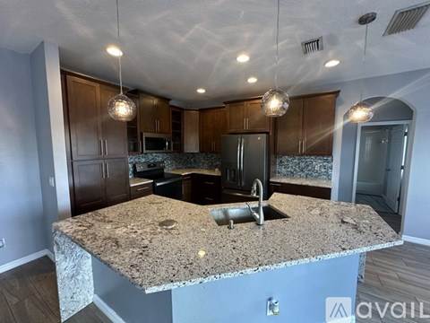 A kitchen with granite countertops and wooden cabinets.