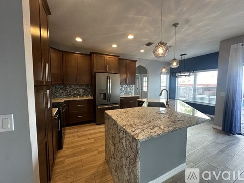 A kitchen with wooden cabinets and a granite countertop.